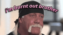 a man with a mustache is wearing a black bandana and says `` i 'm burnt out brother ''