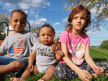 a baby wearing a shirt that says that 's how i roll sits between two children