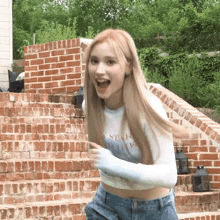 a woman wearing a crop top with the word style on it is standing on a set of brick steps