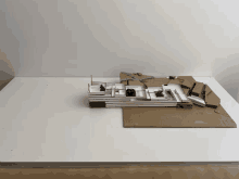 a cardboard model of a building sits on a white surface