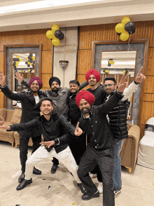 a group of men are posing for a picture with balloons hanging from the ceiling