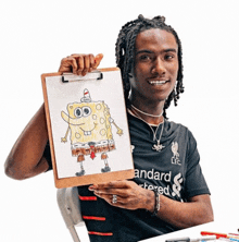 a man holding a clipboard with a drawing of spongebob