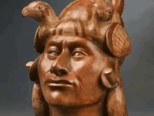 a close up of a wooden statue of a man with turtles on his head .