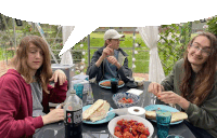 three people are sitting at a table with a bottle of pepsi on it