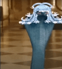 a statue of a snake with a wig on its head is standing on a tiled floor .