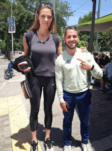 a man and a woman are posing for a picture and the woman is wearing a nike shirt