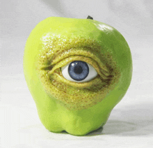 a green apple with a blue eye in it