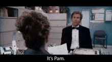 a man in a tuxedo is talking to a woman in a cubicle and the woman is saying it 's pam