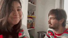 a man and a woman are looking at each other in front of a shelf that has a box that says coca cola