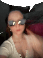 a blurry photo of a woman wearing sunglasses and a white shirt