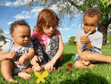 a baby wearing a shirt that says " what 's up " sits with two other children