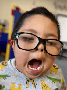 a young boy wearing glasses is making a face