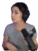 a woman wearing headphones and holding a microphone is sitting in front of a white background .