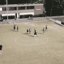 a group of soccer players are playing on a field with a building in the background that has the word tournament written on it