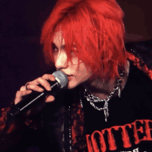 a person with red hair is singing into a microphone and wearing a lotte shirt