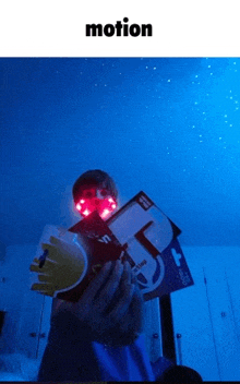 a person wearing a headlamp is holding a book and a box .