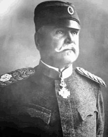 a black and white photo of a man in a military uniform and hat