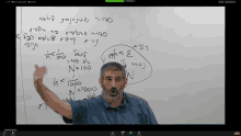 a man is giving a lecture on a whiteboard with arabic writing