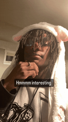 a man wearing a bunny hat has a caption that says " hmmmmm interesting "