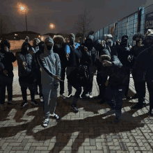 a group of people standing on a brick sidewalk with their faces covered