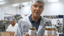 a man holding two jars of bleu blanc roche