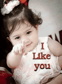 a little girl is pointing at the camera with the words " i like you " written below her