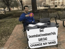 a man is sitting at a table with a sign that says " best decentralized investment polls gari dao change my mind "