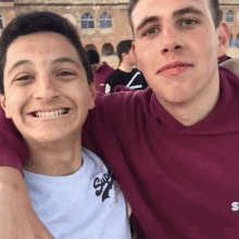 two young men posing for a picture with one wearing a shirt that says super dry