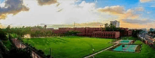 an aerial view of a large grassy field with a building in the background .