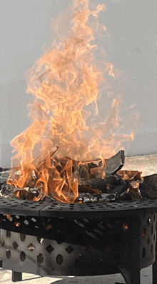 a fire is burning in a metal container with holes in it