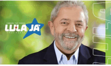 a man with a beard is smiling in front of a lula ja banner