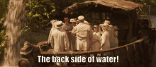 a group of people standing in front of a waterfall with the words the back side of water below them