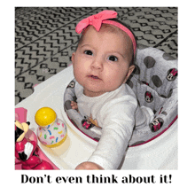 a baby in a minnie mouse walker with the words " do n't even think about it " below