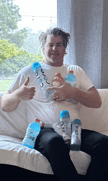 a man sitting on a couch with bottles of gatorade