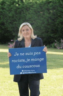 a woman holding a sign that says je ne suis pas raciste