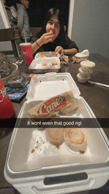 a girl is sitting at a table eating a cane 's sandwich