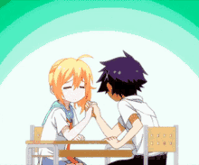 a boy and a girl sitting at a table holding hands