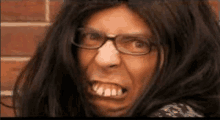 a close up of a man wearing glasses and a wig making a funny face .