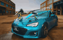 a blue car with a helicopter attached to the top of it