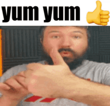 a man with a beard gives a thumbs up with the words yum yum behind him