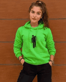 a woman is wearing a neon green billie eilish hoodie .