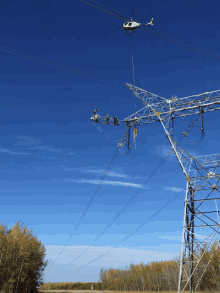 a helicopter is working on a power line in the middle of a field