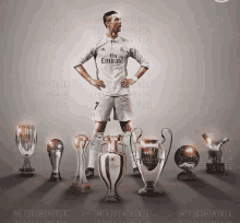 a soccer player wearing a fly emirates jersey stands in front of trophies