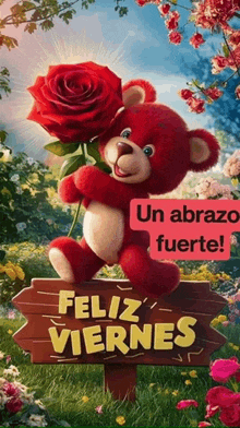 a red teddy bear is holding a red rose and a sign that says feliz viernes