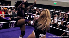 a woman kicking another woman in a wrestling ring with the words wowsuperheroes on the bottom