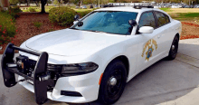 a white kendall police car is parked on the sidewalk