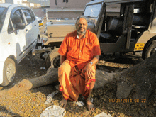 a man sits in front of a vehicle with a license plate that says kl 05