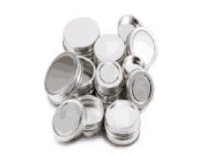 a pile of metal can lids on a white surface .