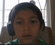 a young boy wearing headphones has a smiley face on his face