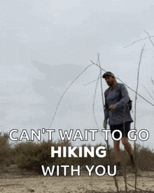 a man hiking in the desert with the words " can 't wait to go hiking with you " above him